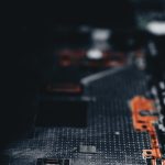 Close-up of a dark circuit board showcasing electronic components and connections.