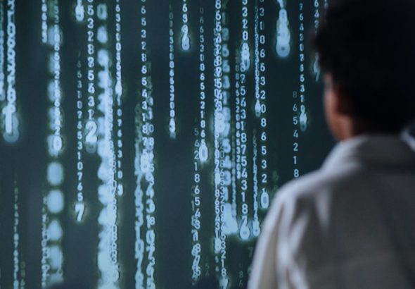 An individual viewing glowing numbers on a screen, symbolizing technology and data.